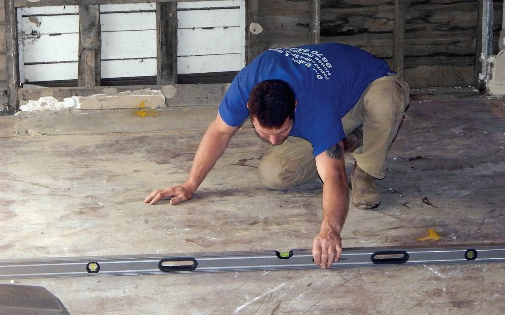 meistras tikrina gulsčiuku grindų lygumą